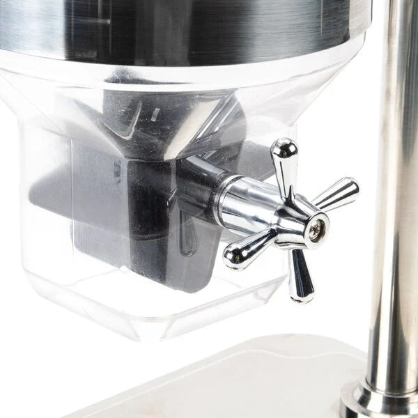 Close-up of a shiny metal cereal dispenser with a transparent container and a chrome paddle handle. The handle is attached to a spout, ideal for dispensing dry food or coffee. The clean, modern design suggests it’s likely a TableCraft product.