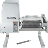 A stainless steel Hobart 403-13 meat tenderizer machine with two roller blades, an on/off switch, a warning label, and the brand logo. A metal cleaning tool with a handle and teeth lies in front; Canada configuration voltage specification available.