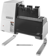 A stainless steel Hobart 403-1 electric knife sharpener with two angled metal legs, black top cover, warning label, indicator light, and a small metal tool placed in front. Features two sharpening slots and US export configuration voltage specification.