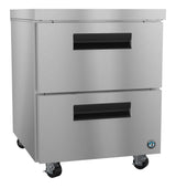 A Hoshizaki undercounter freezer with stainless steel drawers features two horizontal pull-out drawers, black handles, and smooth surfaces. It rests on four caster wheels, with a small round logo on the bottom right corner of the unit.