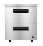 A Hoshizaki undercounter refrigerator with two horizontal black handles—one on the upper door, one on the lower drawer—features a brushed stainless finish, black adjustable feet, and a small circular certification logo in the bottom right corner.