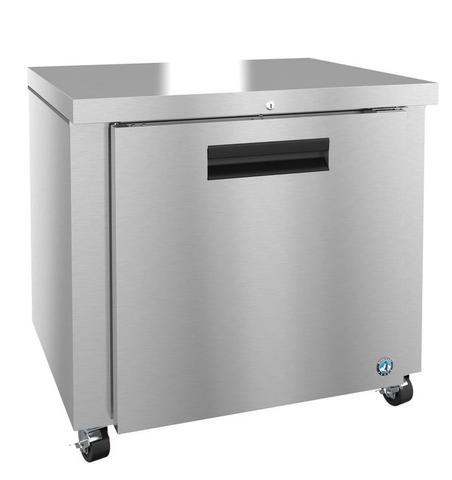 A stainless steel Energy Star undercounter refrigerator with a single front door, black recessed handle, lock, flat top, and four caster wheels for mobility. The brushed metal finish features a small blue logo on the lower right corner.
