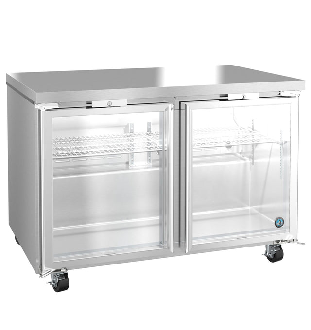 A commercial glass door refrigerator with two clear doors, metal shelving, and secure lock mechanisms. This stainless steel refrigerator features four wheels for mobility and a brushed finish, with the interior empty and clean.