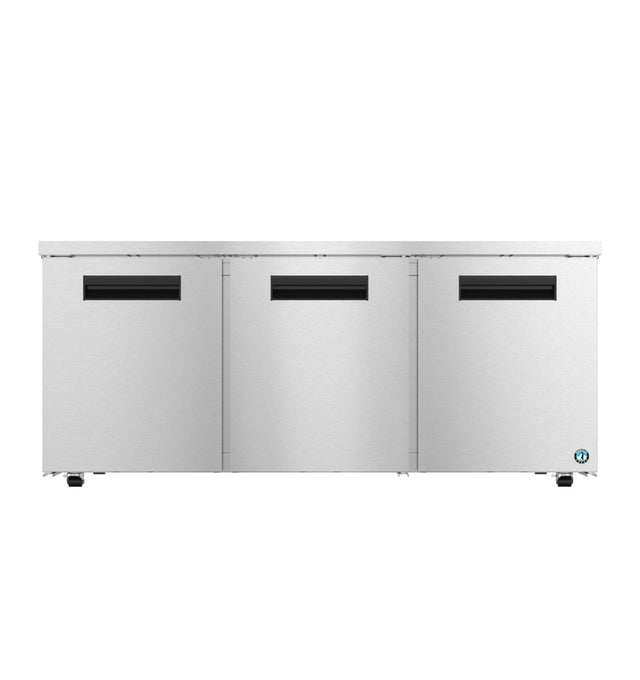 A large, commercial Hoshizaki UR72B-LP undercounter low profile refrigerator with three front doors, each featuring a rectangular black handle slot. The smooth stainless steel surface has a small blue logo in the bottom right corner. Background is plain white.