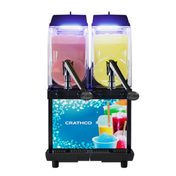 A dual-tank Crathco I-PRO 2M frozen granita dispenser with blue lighting, holding pink and yellow slush drinks. Each tank has a push handle for dispensing, and the lower front showcases colorful drinks in cups and the CRATHCO brand name.