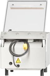 A Berkel 250-STD vacuum packaging machine with a single stainless steel chamber, clear hinged lid, yellow electrical plug, black cord draped in front, warning label with a lightning bolt, and four black legs. Interior visible through the open lid.