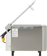 A Berkel stainless steel commercial food slicer with a raised handle, yellow electrical plug, and caution label stands on four black legs against a plain background, pairing perfectly with a single chamber Vacuum Packaging Machine.