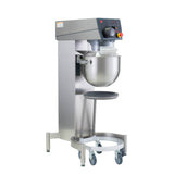 The 20 qt. Varimixer KODIAK Food Mixer features a large stainless steel mixing bowl, digital control panel, safety guard, and wheeled base for mobility. This silver mixer has a black handle and a mobile platform beneath the bowl for added convenience.