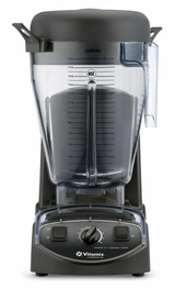 A black Vitamix XL Blender with a large clear plastic pitcher marked with measurements in ounces and liters, a spout, and a black lid. The commercial blender base features a central dial, switches, and branding, set against a plain white background.