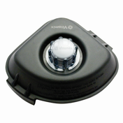 A black Vitamix lid for Advance containers, featuring a clear plastic removable center cap and rubber plug, is shown from above on a white background. The Vitamix logo is embossed near the cap, with cautionary text printed along the edge.
