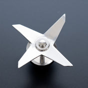 A close-up of a shiny, metal Vitamix wet blade assembly on a dark textured surface, viewed from above. The sharp blades radiate from a round central hub—an essential part for Vitamix standard containers and a popular choice for replacement parts.