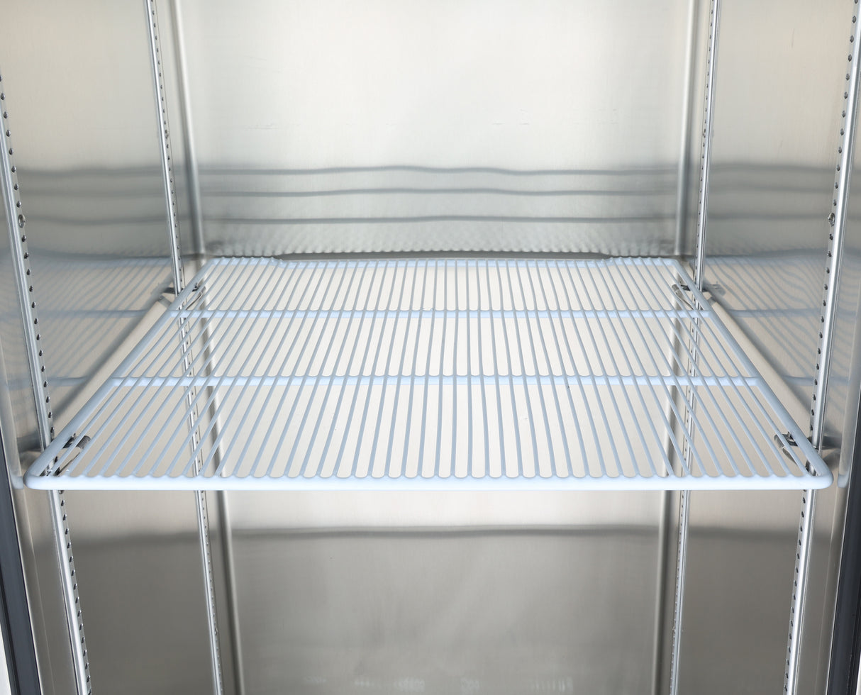 A metal wire shelf inside an empty stainless steel Atosa USA refrigerator or storage unit. The white shelf, held by sturdy shelf clips, features evenly spaced bars and sits in the middle against a reflective, clean metallic interior.