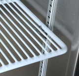 A close-up of a white metal wire shelf, supported by adjustable shelf clips, installed inside a stainless steel Atosa USA cabinet. The slotted rails and clean lines enhance the industrial appeal of this storage solution.