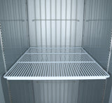 A clean, empty metal Additional Shelf with white wire bars and sturdy shelf clips sits inside a gray Atosa USA fridge interior with vertical ridges. No items are present, and the lighting is bright and evenly distributed.