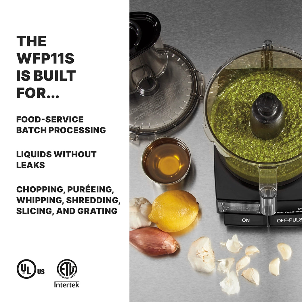 A commercial food processor with green sauce inside sits on a gray counter beside olive oil, lemon, shallot, garlic cloves, and cheese. Text explains the WFP11S batch bowl food processor features the LiquiLock Seal System for leak-free batch processing.