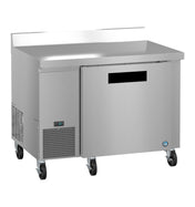 A stainless steel worktop refrigerator with one solid door, ENERGY STAR certification, a ventilation grill on the lower left, digital display, four caster wheels, and a raised backsplash—all set against a white background.