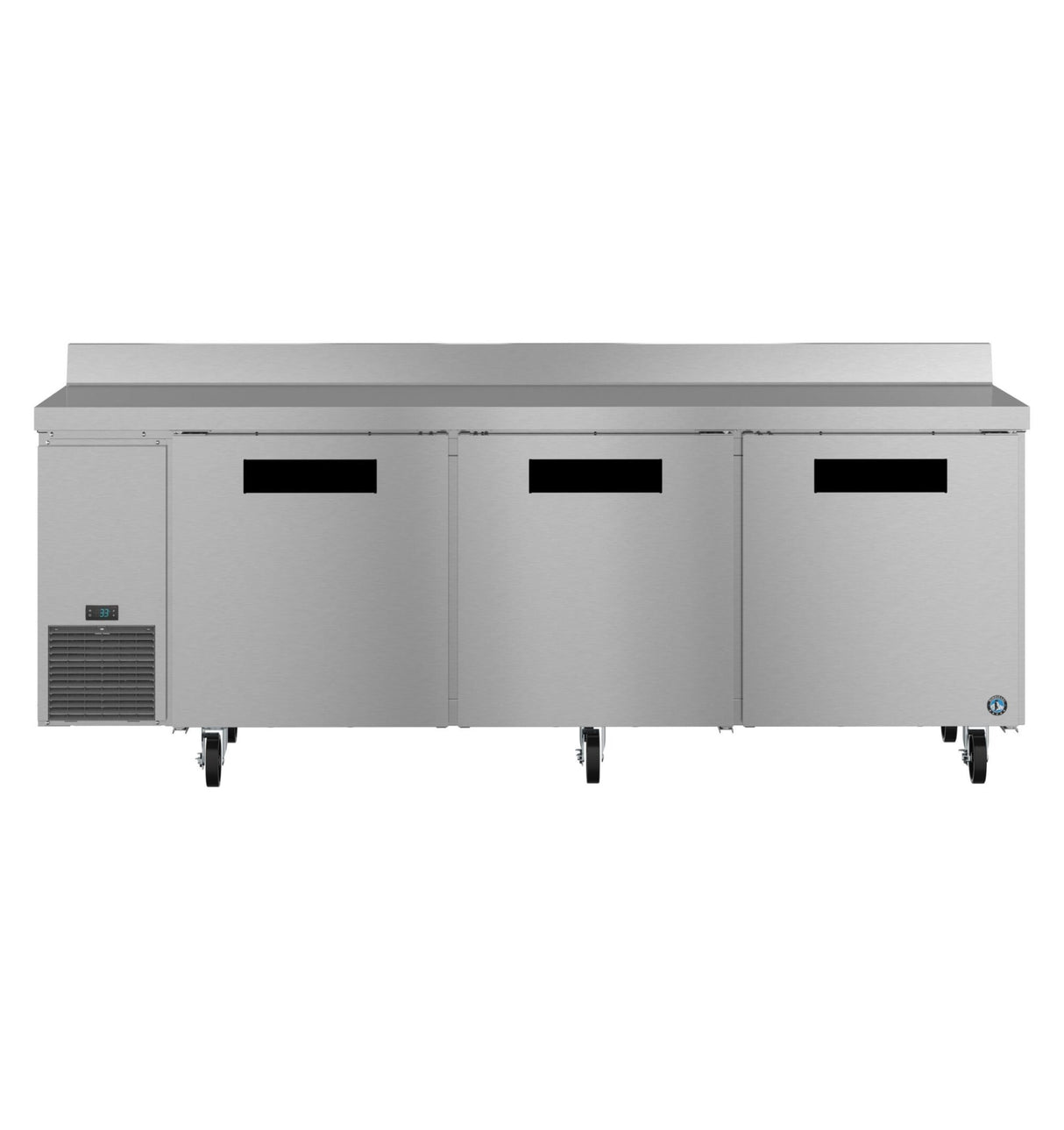 A large commercial stainless steel worktop refrigerator with three doors, black handles, and a vented cooling unit on the left. The table features a raised backsplash and sits on caster wheels for easy mobility. ENERGY STAR certified for efficiency.
