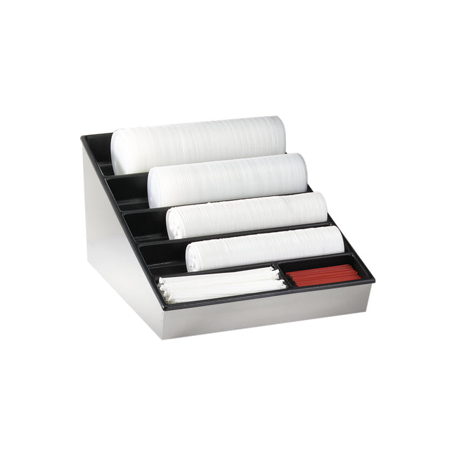 A sleek black and metallic lid organizer holds stacked white plastic lids in four angled rows, alongside red and white stirrers in two front compartments. This stylish countertop condiment organizer is perfect for dispensing coffee accessories. The background is plain white.