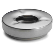 A round, stainless steel ashtray with a smooth, shiny surface and recessed center. The minimalist design features a slightly raised edge and three narrow slots for cigarettes. This modern ashtray is also dishwasher safe for easy cleaning.