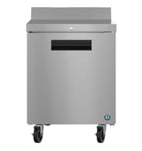 A stainless steel worktop refrigerator with a single front door, black recessed handle, and four caster wheels. Its smooth surface features a small lock above the handle and an ENERGY STAR certification sticker on the lower right corner.
