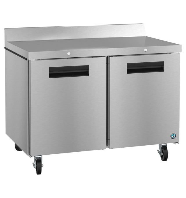A commercial stainless steel worktop refrigerator with two doors, black handles, a raised back edge, and four wheels for mobility. The flat, reflective surface adds durability, making it perfect for any professional kitchen. ENERGY STAR certified for efficiency.