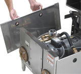 A person lifts a stainless steel panel from a Hobart WastePro self-contained pulper, revealing internal mechanical components like pipes, wiring, and a motorized drain valve. The unit is labeled COLD and INCOMING with visible warning and instruction labels.