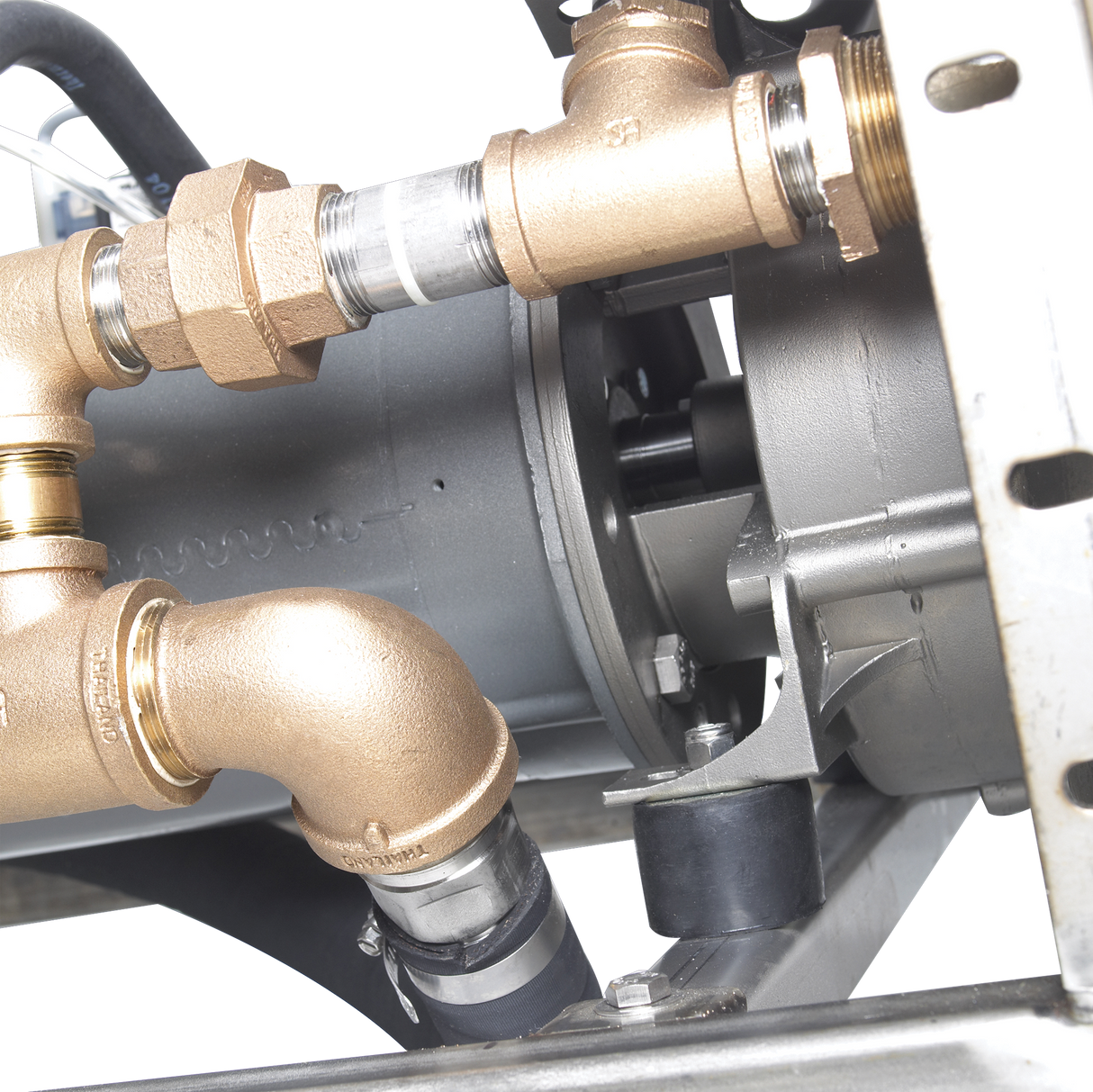Close-up of industrial plumbing connections with brass fittings attached to a cylindrical gray metallic component, likely a Hobart WastePro self-contained pulper or motorized drain valve, mounted on a metal bracket against a black background.