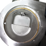 A close-up view of a shiny metal industrial machine, possibly a WastePro self-contained pulper, showing a circular opening with a perforated plate and smooth inner chamber. The well-maintained machine is likely used for processing or separating materials.