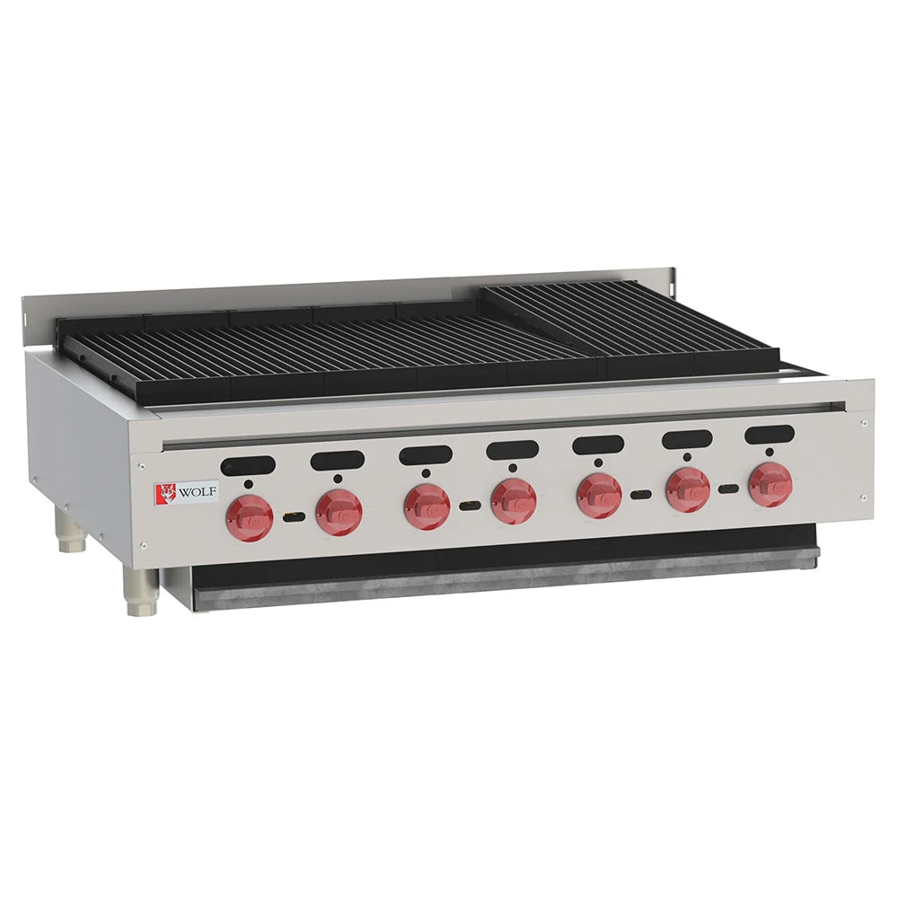 This Wolf commercial gas charbroiler features six red control knobs, black grill grates, and a durable stainless steel body. The raised back and sides enhance safety, while the unit stands on four legs with the brand logo displayed on the front left panel.