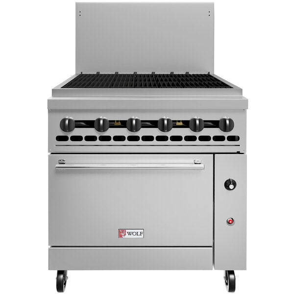 A Wolf Challenger Restaurant Range featuring a black grated stovetop, six control knobs, commercial convection oven below, small red and white Wolf logo, metal backsplash, and wheels at the base for mobility.