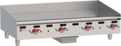 A heavy duty countertop gas griddle with four red control knobs, a flat cooking surface, raised back and side splashes, short metal legs, and the Wolf brand logo displayed on the left of the stainless steel front panel.