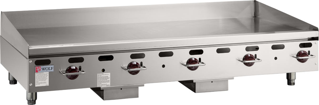 A large commercial gas griddle, the Wolf AGM60_NAT features four red control knobs, vent holes, a backsplash, and a flat stainless steel surface. This heavy duty griddle stands on short legs with the Wolf brand label visible on the left side.
