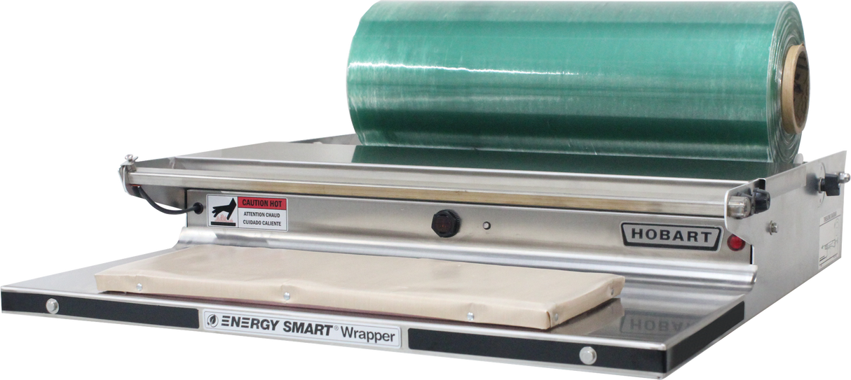 A commercial Energy Smart Table Top Wrap Station with a stainless steel wrapping surface, a large green film cradle mount, heated metal sealing plate, labeled “Hobart,” and a caution for hot surfaces.