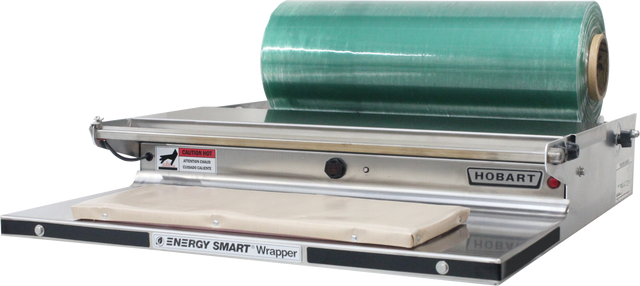 A commercial Energy Smart Table Top Wrap Station with a stainless steel wrapping surface, a large green film cradle mount, heated metal sealing plate, labeled “Hobart,” and a caution for hot surfaces.