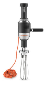 A black KitchenAid commercial-grade hand mixer with a side handle and an orange power cord coiled at the base. Styled like a heavy duty immersion blender, it features a large stainless steel whisk and the brand name on a silver band around the body.