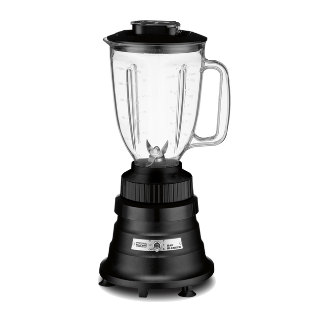 A countertop bar blender with a clear copolyester container, black lid, visible stainless steel blades, and a sturdy black base featuring a silver control panel and dial; the jar has a handle and measurement markings. The background is plain white.