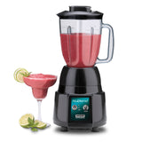 A black NuBlend commercial blender with a polycarbonate container is filled with a red smoothie on a white surface. Next to it, a cocktail glass holds the same smoothie, garnished with lime slices and extra lime wedges nearby.