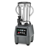 A heavy-duty Food Blender with a large stainless steel container, side handles, black lid, and a sturdy gray base featuring control buttons and a digital display labeled CB15 THE CLASSIC.