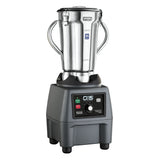 A commercial blender with a large stainless steel container, sturdy side handles, and a black base featuring variable speed control, labeled buttons, a dial, and indicator lights. The Waring brand is visible on the jar’s lid.