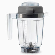 A clear, BPA free 32 oz blender container with measurement markings, a left-side handle, and a dark gray lid. Stainless steel blades sit at the base, designed to fit on a Vitamix blender. The background is plain white.