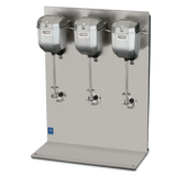A stainless steel triple spindle drink mixer with three large mixing heads, each with a spindle and beater, mounted on a vertical metal backing plate. The countertop base is flat and polished. The Waring Commercial brand name is visible.
