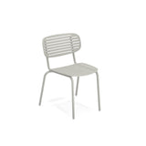 The Mom Stacking Side Chair is a light gray, solid steel metal chair with a curved backrest and horizontal slats. Perfect for outdoor/indoor use, it features four tubular legs and a minimalist, modern design, photographed on a white background.