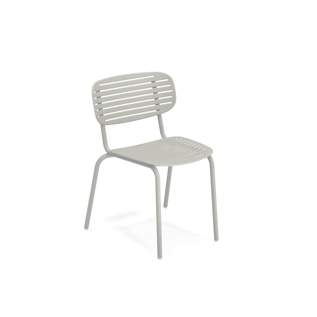 The Mom Stacking Side Chair is a light gray, solid steel metal chair with a curved backrest and horizontal slats. Perfect for outdoor/indoor use, it features four tubular legs and a minimalist, modern design, photographed on a white background.