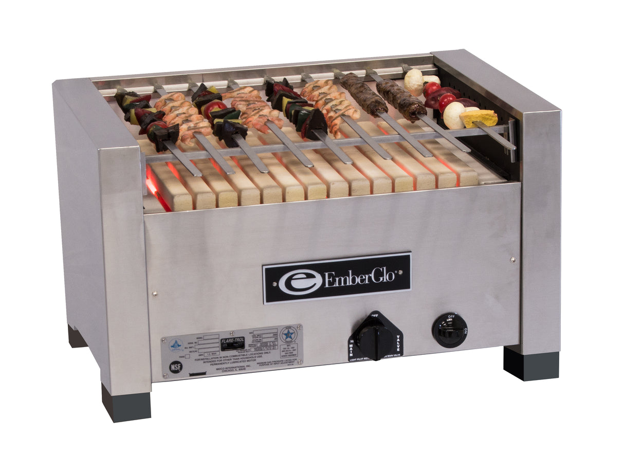 A stainless steel Kabob Charbroiler EmberGlo grill with skewers of assorted meats and vegetables cooks over heating elements inside the compact, boxy grill, featuring a visible control knob and manufacturer label on the front.