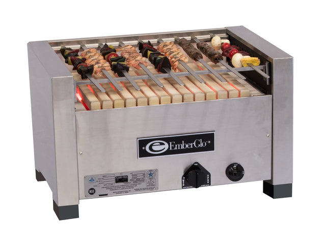 A stainless steel Kabob Charbroiler EmberGlo grill with skewers of assorted meats and vegetables cooks over heating elements inside the compact, boxy grill, featuring a visible control knob and manufacturer label on the front.