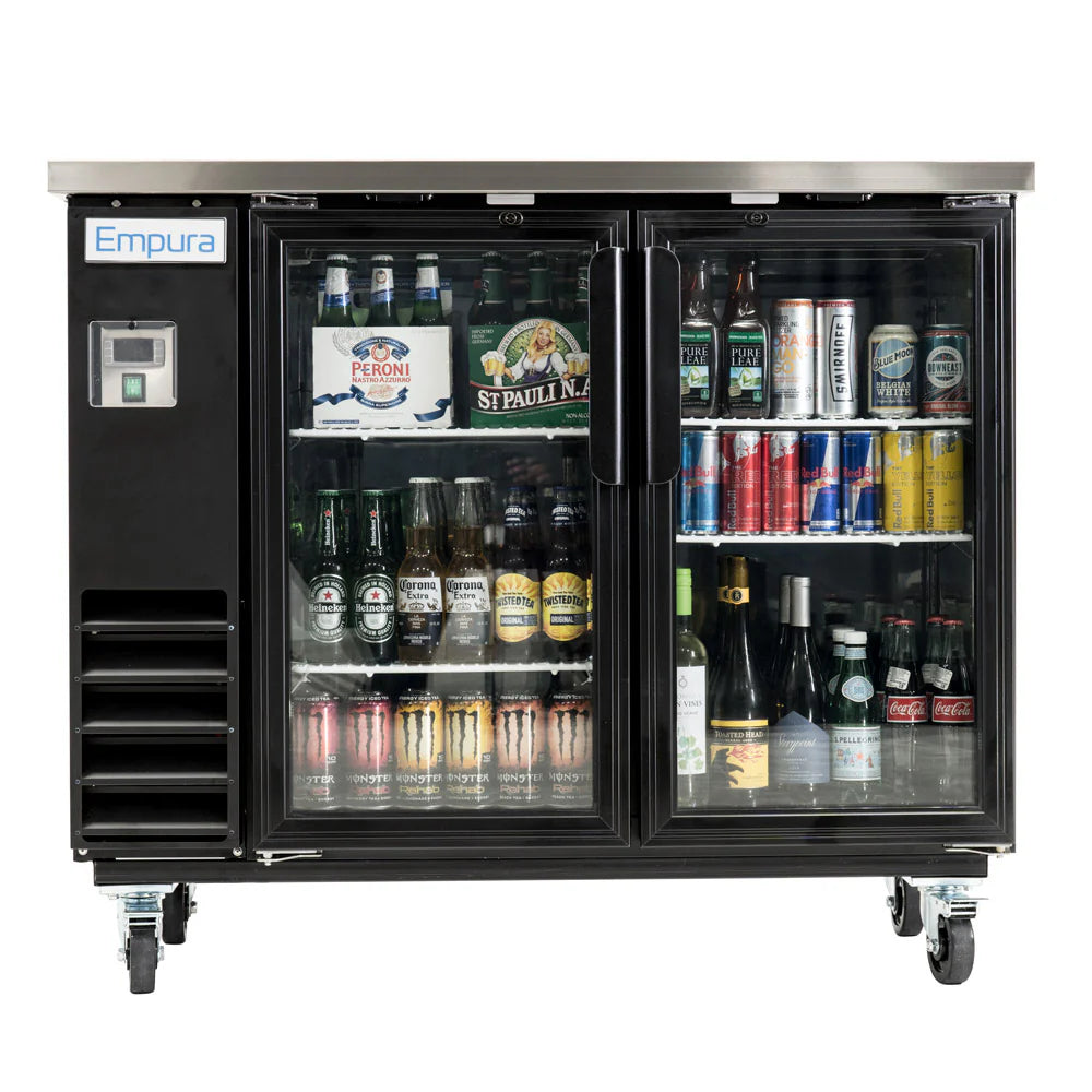 An Empura Refrigeration Glass Door Cooler displays assorted beverages—bottled beers, canned sodas, wine, and energy drinks. This back bar cooler features two doors with metal handles, smooth-rolling wheels, and neatly organized rows of drinks.