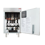 The image shows an open metal commercial fryer control box. Inside, three black heat exchanger tubes, wiring, dials, and various mechanical components are visible. The open door features safety and operating instructions printed on the inner panel.