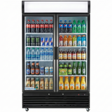 A commercial Empura refrigeration merchandiser with glass swing doors displays assorted beverages—soda, water, energy drinks, juice, and iced coffee—on five well-lit shelves. Brands like Coke, Pepsi, Monster, Snapple, and Starbucks are visible.