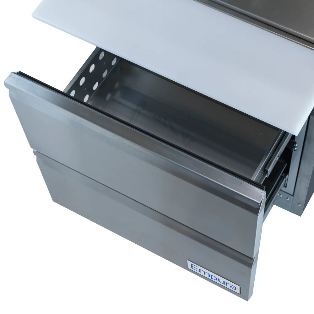 A stainless steel refrigerated sandwich prep table drawer is pulled open, revealing an empty interior. The unit has a clean, modern design with a perforated metal side, white cutting board on top, and a blue and white Empura label on the front.