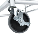 Close-up of a black caster wheel attached to a sturdy aluminum pan rack frame. The wheel has a gray tire and features an engaged metal brake lever, securely locking the wheel in place. The silver hardware appears industrial and durable.